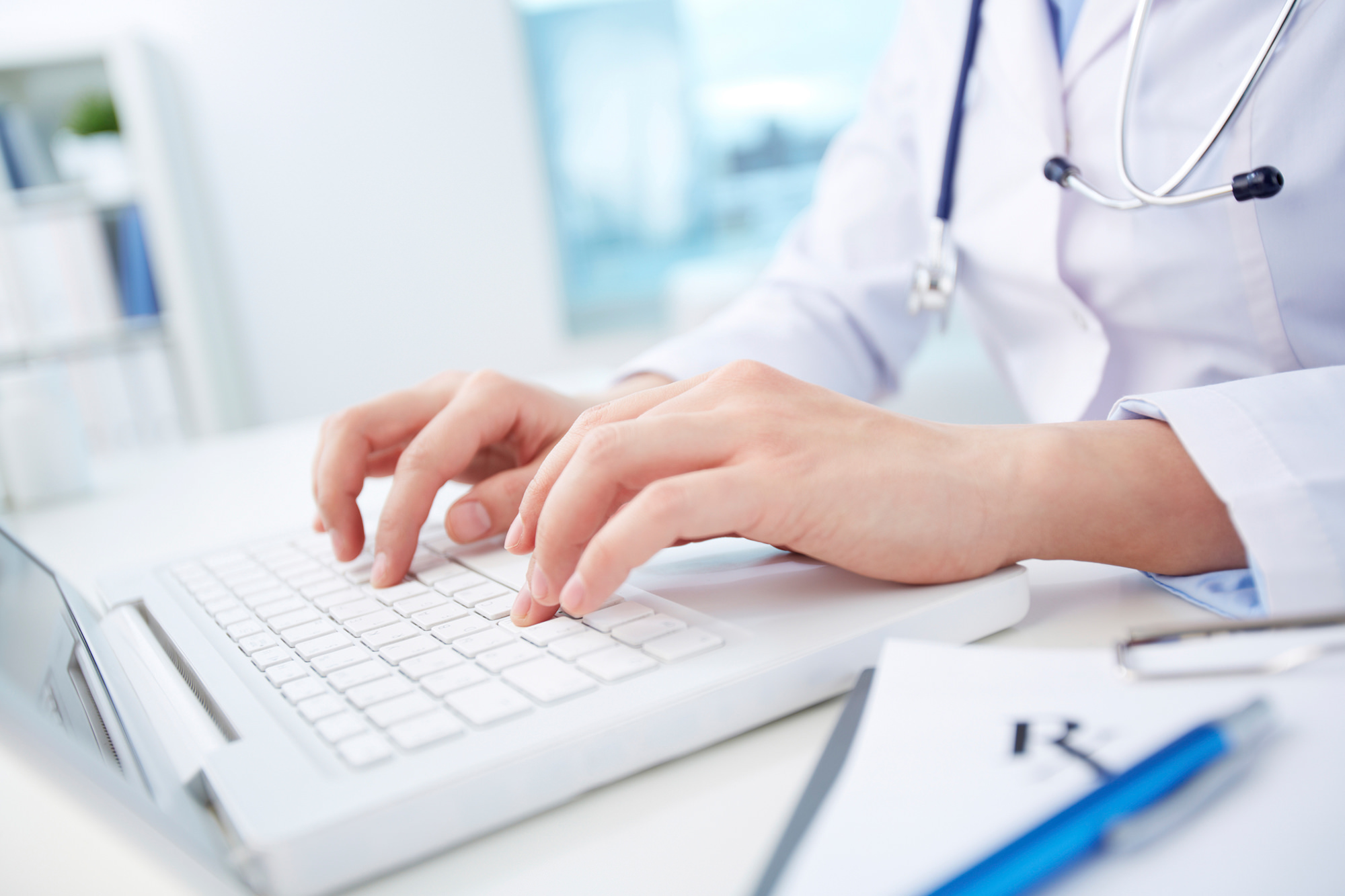 A physician typing on a keyboard